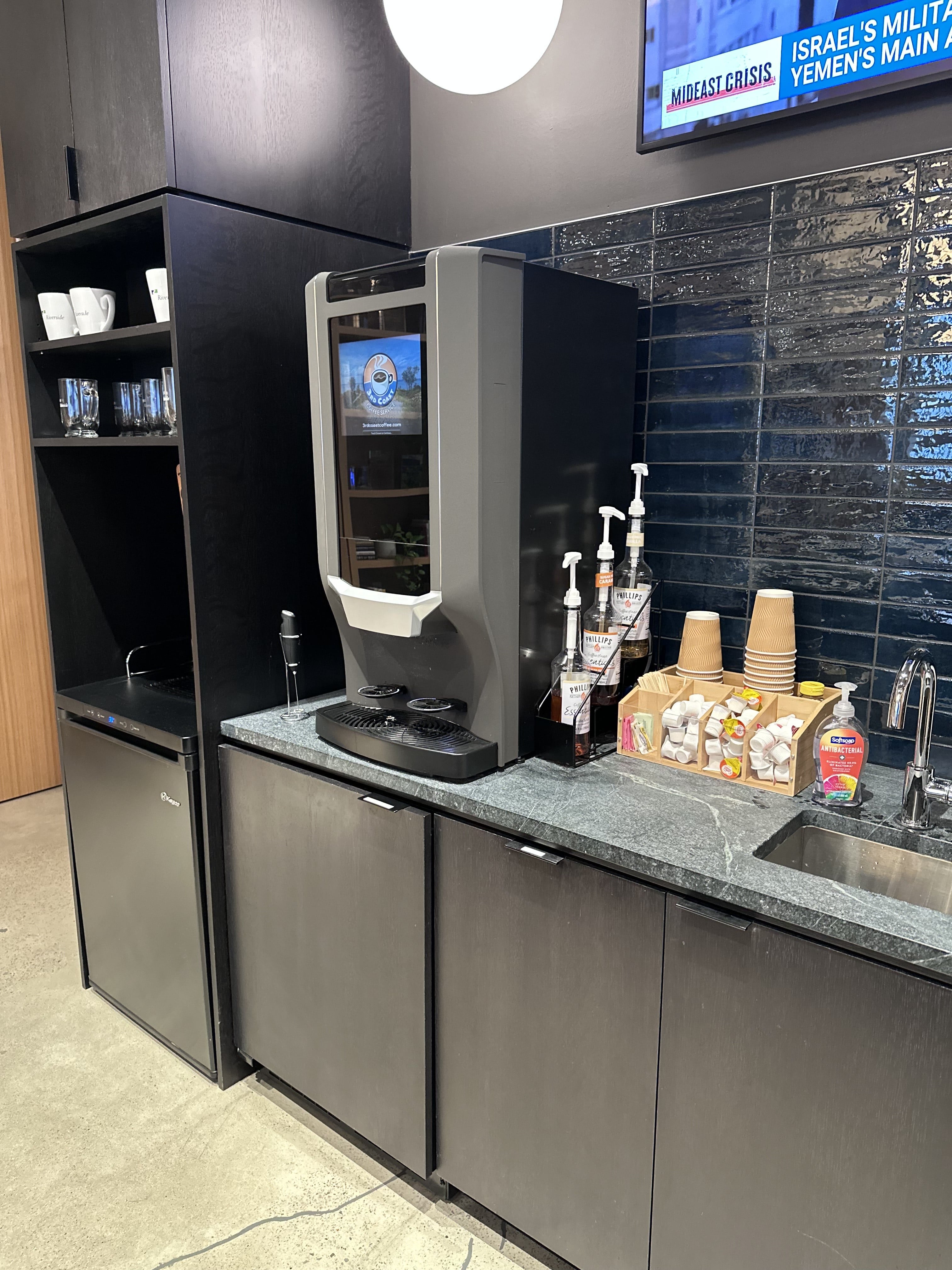 Commercial coffee machine station with cups, dispensers, and a variety of coffee accessories