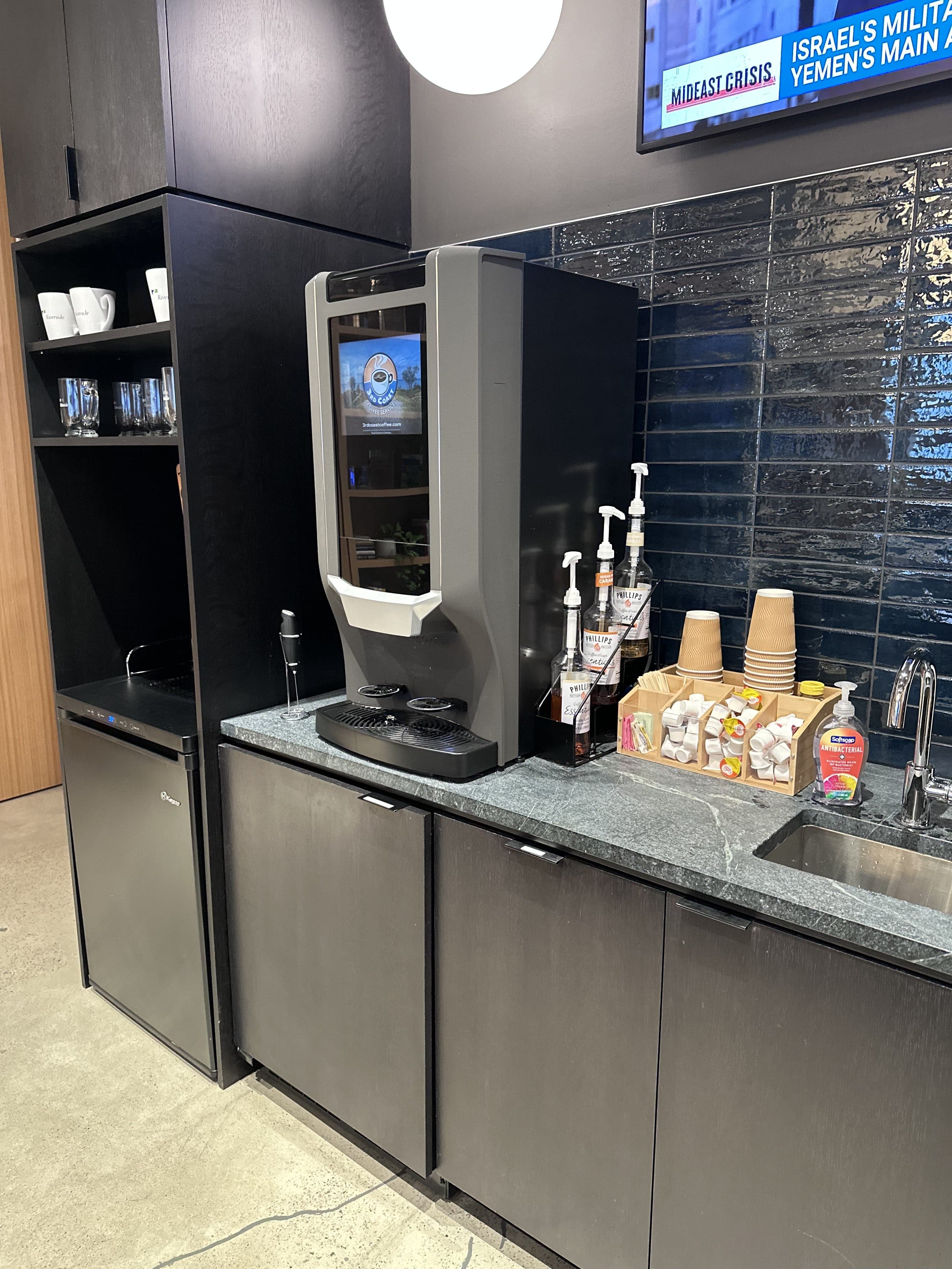 Commercial coffee machine station with cups, dispensers, and a variety of coffee accessories